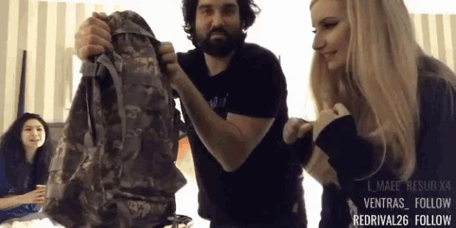 a man is holding a backpack while a woman looks on and a watermark that says redrival26 follow