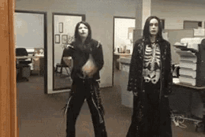 a man in a skeleton costume is standing next to another man in a black coat