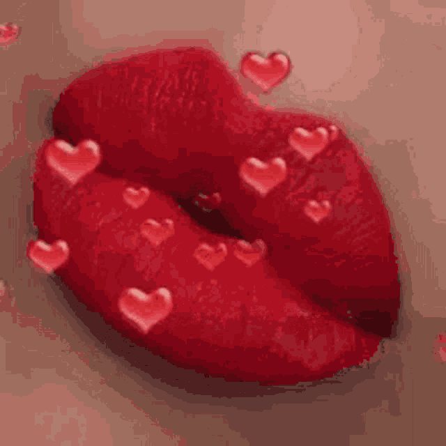 a close up of a woman 's lips with red lipstick and hearts coming out of them .