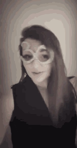 a woman wearing a black top and white glasses with the number 30 on them .