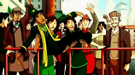 a group of people are standing around a fence and a man is holding a woman in his arms .