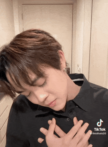 a tiktok video of a young man with his hands on his heart