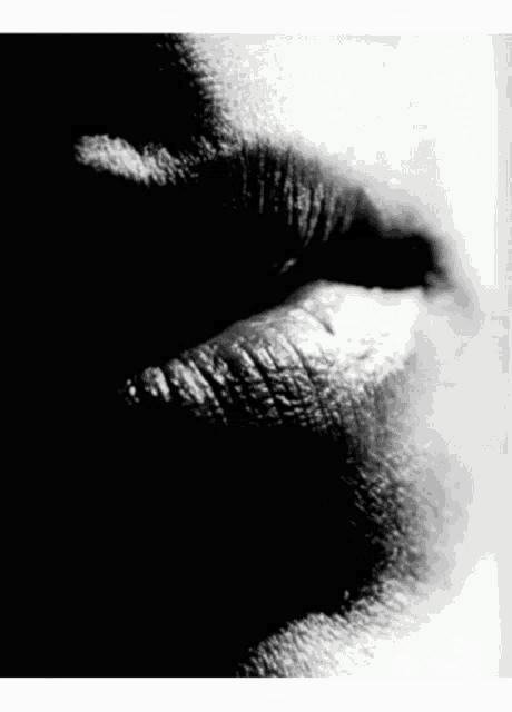 a black and white photo of a woman 's lips with lipstick on .