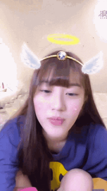 a girl wearing a headband with angel wings and a halo around her head
