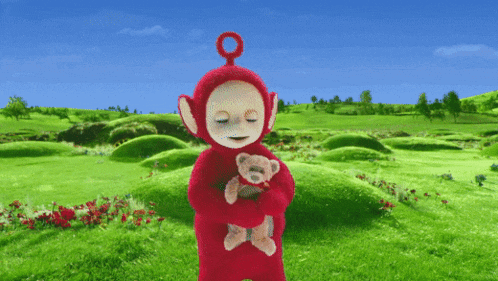 a teletubbies character is holding a teddy bear