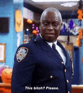 a man in a police uniform is standing in a room and saying this bitch please .