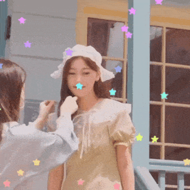 a girl wearing a white hat is being touched by another woman