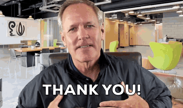 a man in a jacket says thank you in front of an office