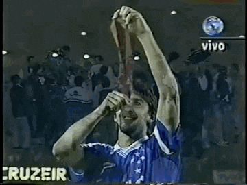 a man in a blue soccer jersey is holding a soccer ball in his hand .