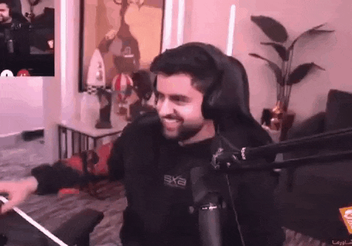 a man is sitting in a chair in front of a microphone in a living room .