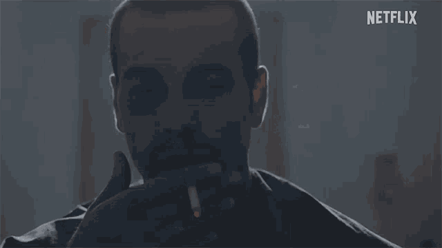 a man with a black eye is smoking a cigarette with a netflix logo in the background