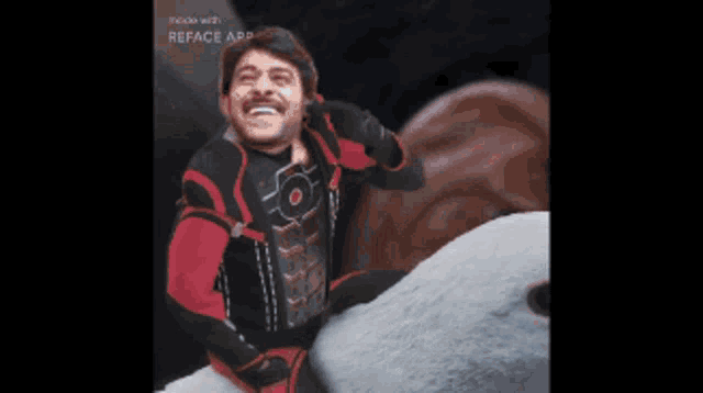 a man in a red and black superhero costume is sitting on a shark