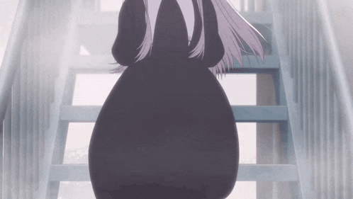a woman in a black dress walking down stairs