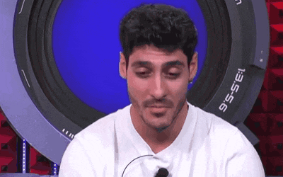 a man is sitting in front of a camera with his eyes closed and a microphone in his mouth .