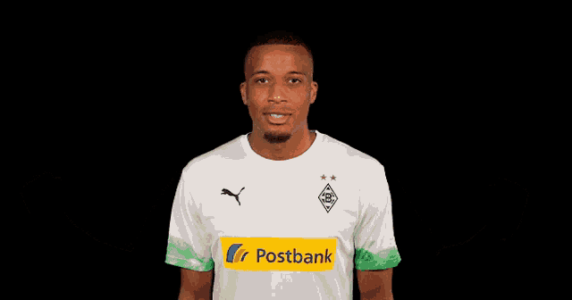 a man wearing a white shirt with a postbank logo on the front
