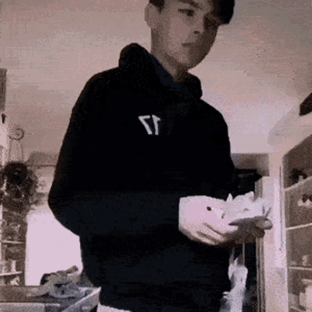 a young man wearing a black hoodie with the letter r on it