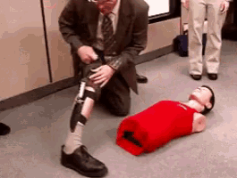 a man with a prosthetic leg is kneeling next to a mannequin