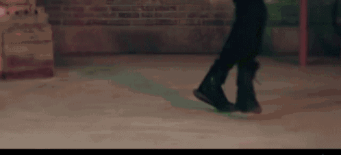 a close up of a person 's feet walking on a brick floor .