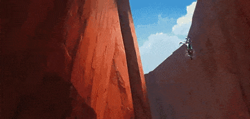 a person is riding a motorcycle down a cliff .