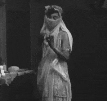 a woman in a white dress with a veil on her face