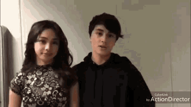 a man and a woman are standing next to each other and looking at the camera .