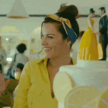 a woman in a yellow shirt is smiling in front of a lemon