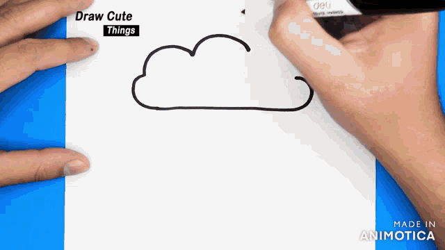 a person is drawing a cloud with a marker on a piece of paper