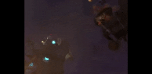 a blurred image of a robot flying through the air with fire coming out of it 's mouth .
