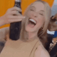 a woman is drinking a drink from a bottle while making a funny face .
