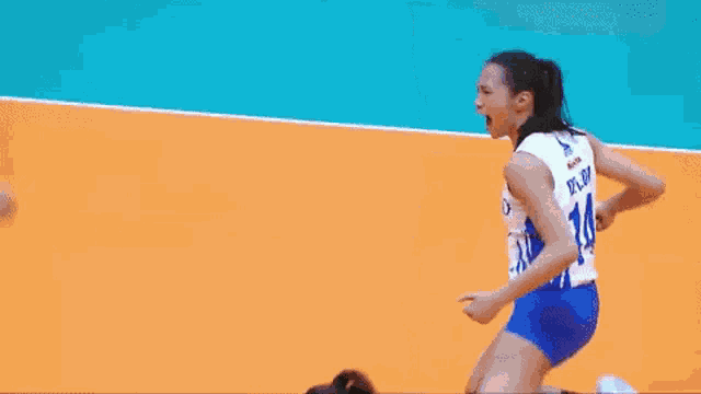 a female volleyball player is celebrating a point during a game on a court .