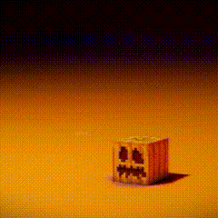 a block with a face carved into it is sitting on a yellow surface .