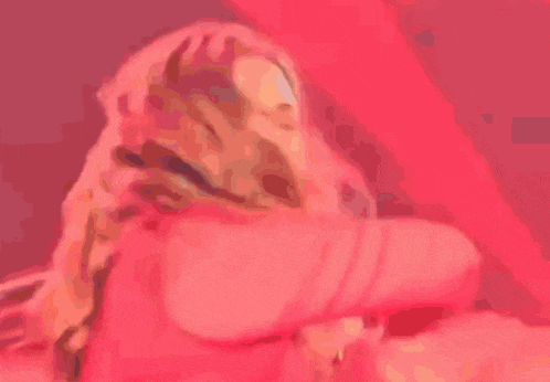 a woman in a red shirt is dancing on a stage .
