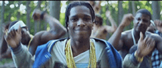 a group of men are dancing in the woods and one of them is wearing a blue jacket .