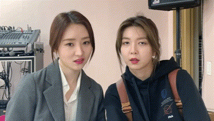 two women are standing next to each other in a room and making faces .