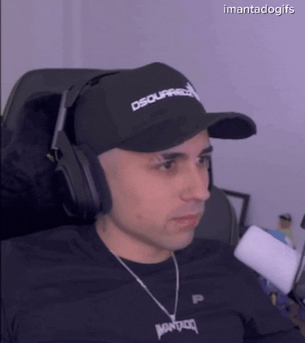 a man wearing a black hat and headphones is sitting in a chair .
