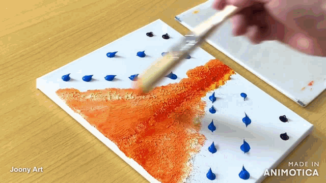 a person is painting with a brush on a canvas that says made in animotica