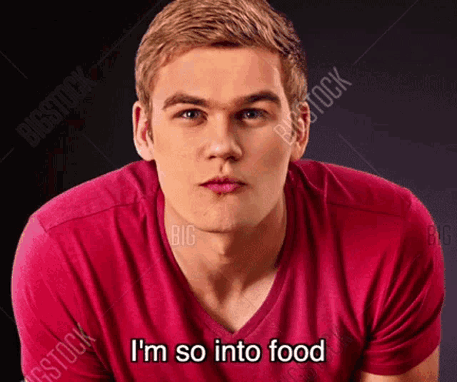 a young man in a red shirt is making a funny face and saying i 'm so into food .
