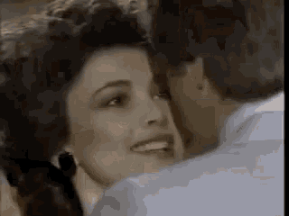 a man is kissing a woman on the cheek while they are dancing .