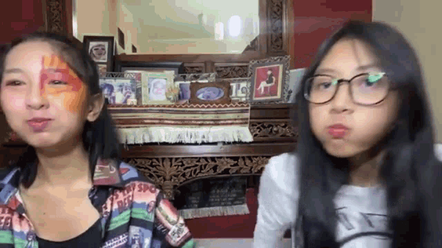 two young girls are sitting next to each other in a living room .