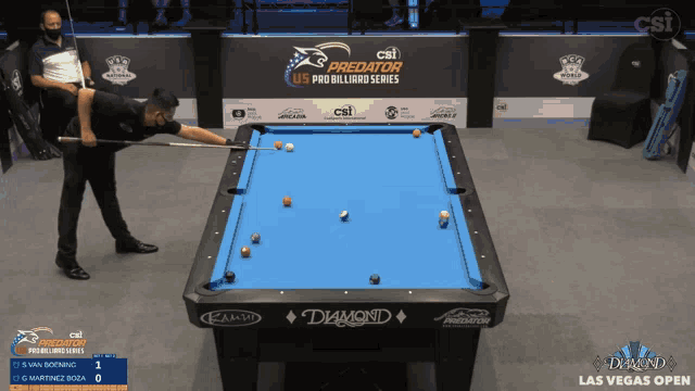 a man is playing pool in front of a wall that says csi predator