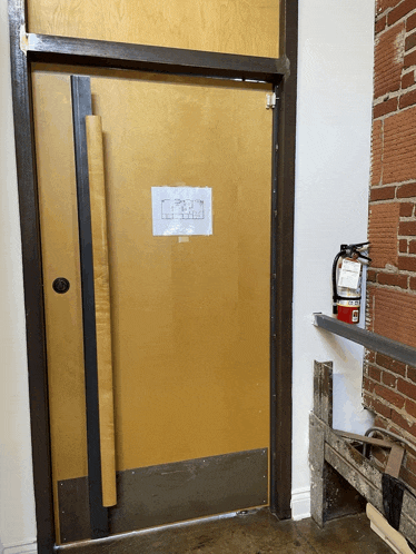 a fire extinguisher sits on a shelf in front of a door