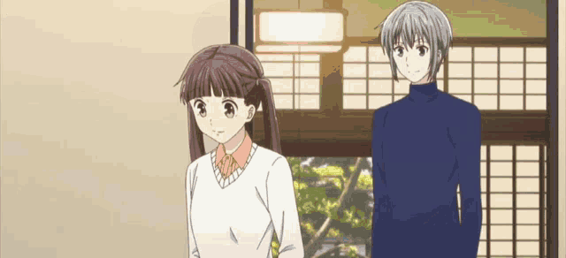 a man and a girl are standing next to each other in a room .