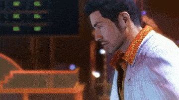 a man in a white shirt with a red collar is looking down
