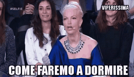 a woman in a blue dress is sitting in front of a crowd and says come faremo a dormire .