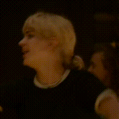 a woman is pointing at a man in a black shirt in a pixelated image .
