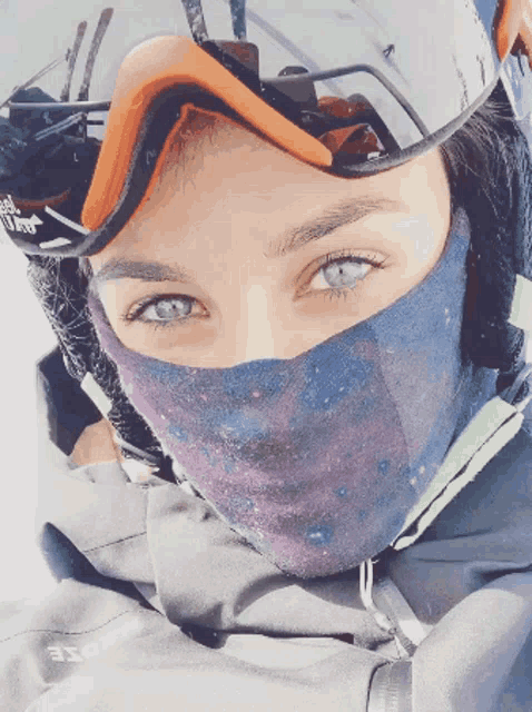 a woman wearing a ski mask and a helmet with a sticker that says ' salomon ' on it