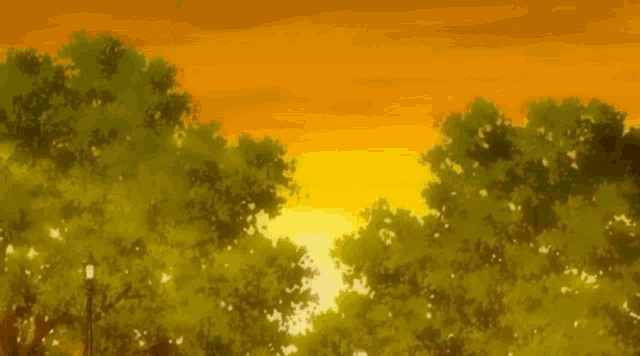 a sunset in a park with trees and a street light in the foreground