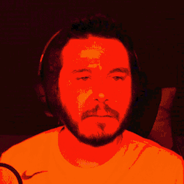 a man with a beard wearing headphones and a yellow nike shirt