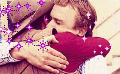 a man in a hat is hugging another man in a red shirt