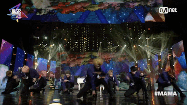 a group of dancers on a stage with the hashtag #mama